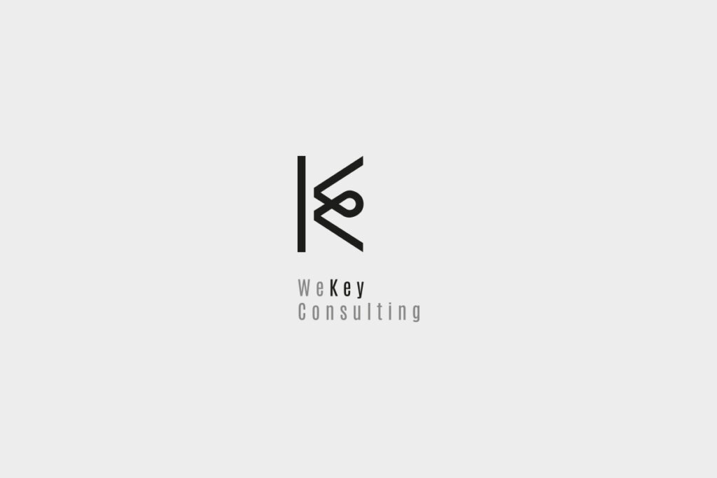 Logo di WeKey Consulting con design minimalista nero su sfondo grigio chiaro. Il logo mostra una combinazione stilizzata delle lettere "W" e "K" con una linea verticale.