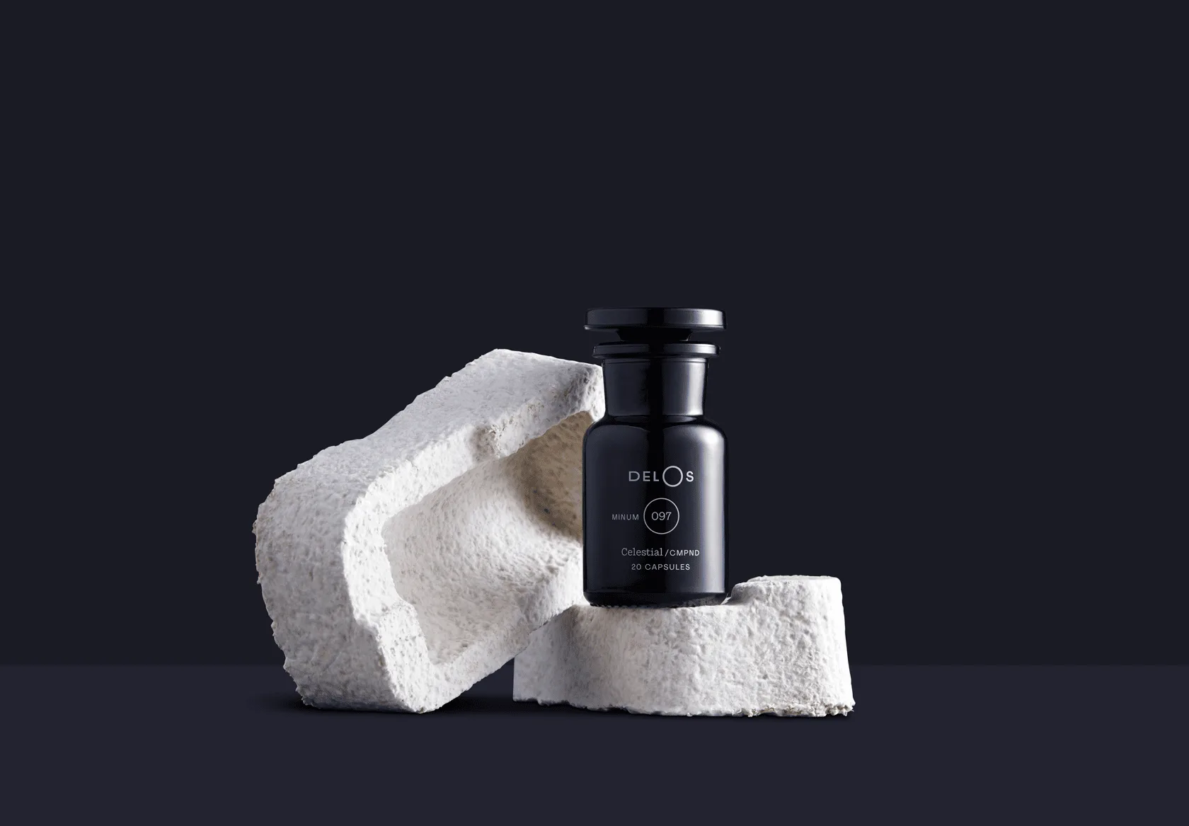 Flacone nero di capsule Delos e del suo packaging prodotto con i funghi