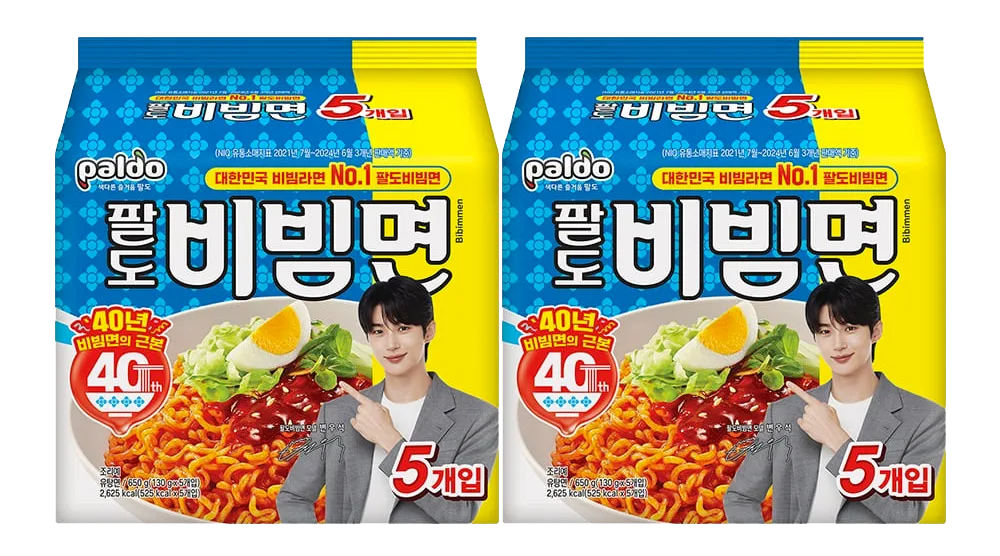 Confezione di Paldo Bibimmyeon, il famoso ramen coreano freddo, con noodles, salsa piccante dolce e guarnizioni di uova e verdure fresche. Design celebrativo per il 40° anniversario
