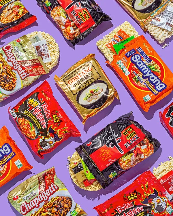 Immagine di confezioni di ramen coreano disposte su uno sfondo viola. Sono visibili varietà popolari come Shin Black, Buldak Hot Chicken, Chapagetti, Samyang Ramen e altri gusti iconici.