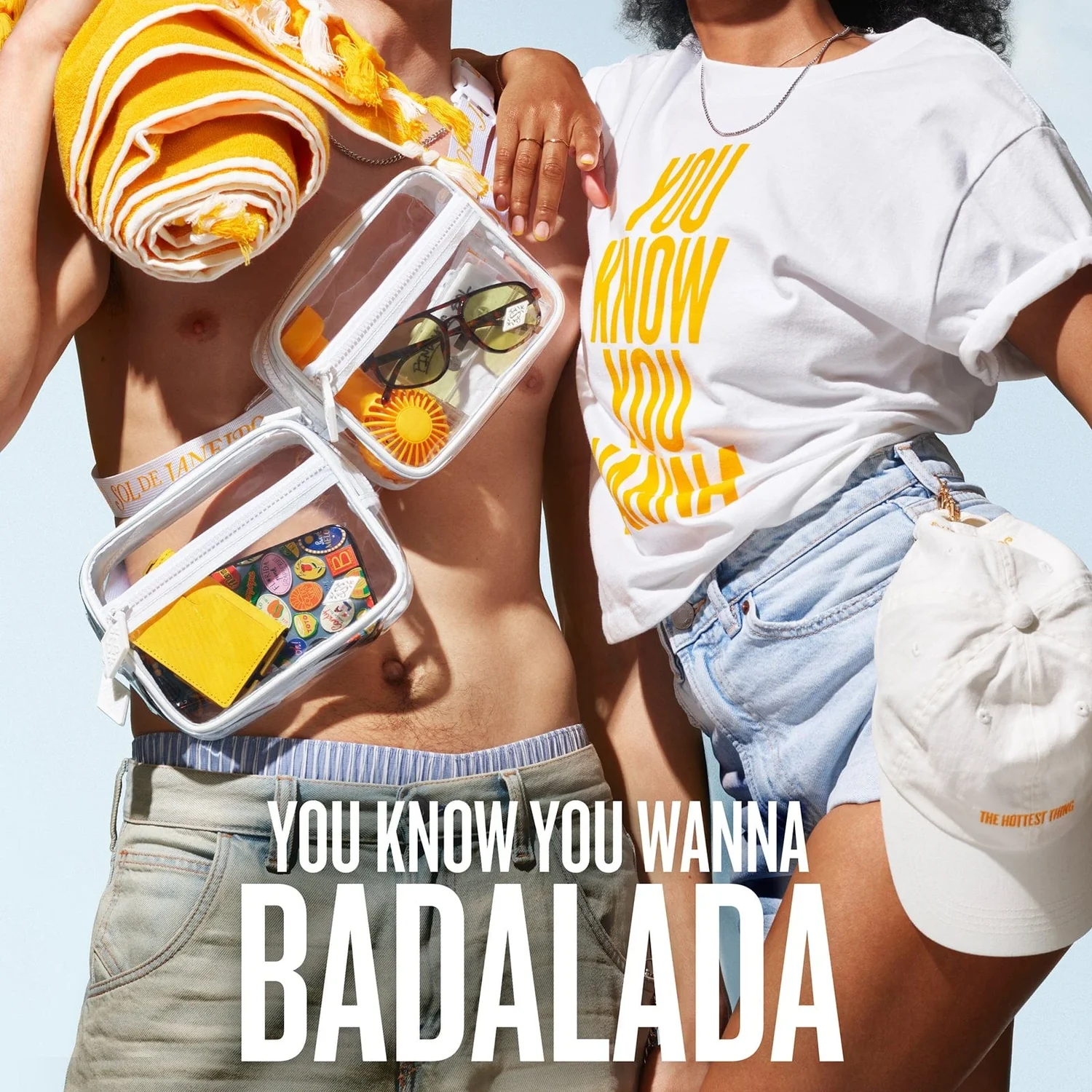 Immagine della campagna Badalada del brand cosmetico brasiliano Sol De Janeiro. La campagna raffigura un ragazzo a torso nudo con il telo da mare giallo sulla spalla con due cofanetti trasparenti Bum Bum Jet Set e una ragazza con t-shirt e cappellino con lo slogan 'You know you wanna badalada'.