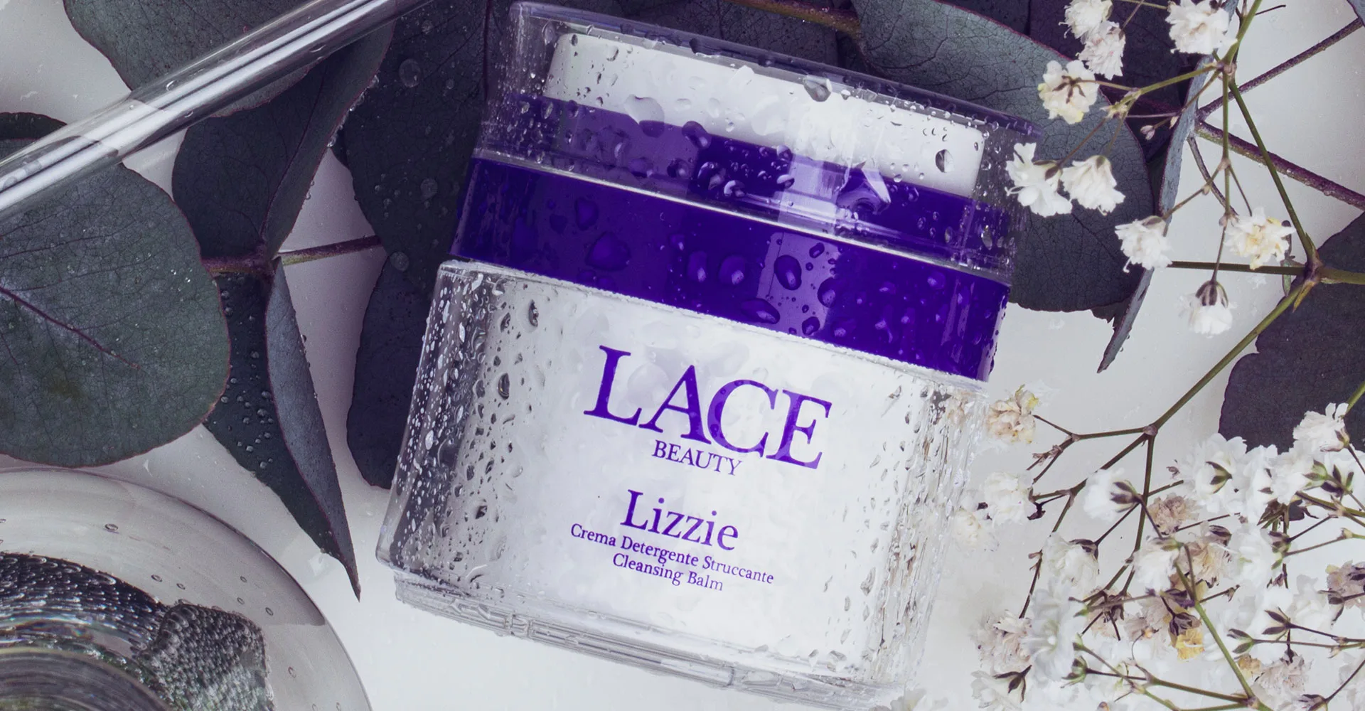 Flacone airless monomateriale Lizzie di Lace Beauty con dettagli viola e tappo trasparente Flacone airless trasparente monomateriale con interno bianco, dettagli viola e tappo trasparente, design minimal Lace Beauty.