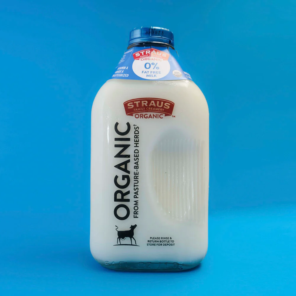 Bottiglia di latte Straus Family Creamery in vetro con tappo blu riutilizzabile, design sostenibile.