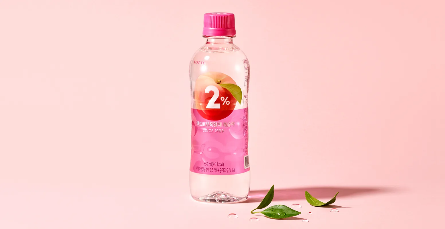 Immagine di una bottiglia di 2% Refreshing Near Water di Lotte su sfondo rosa con 3 foglioline verdi e gocce d'acqua.