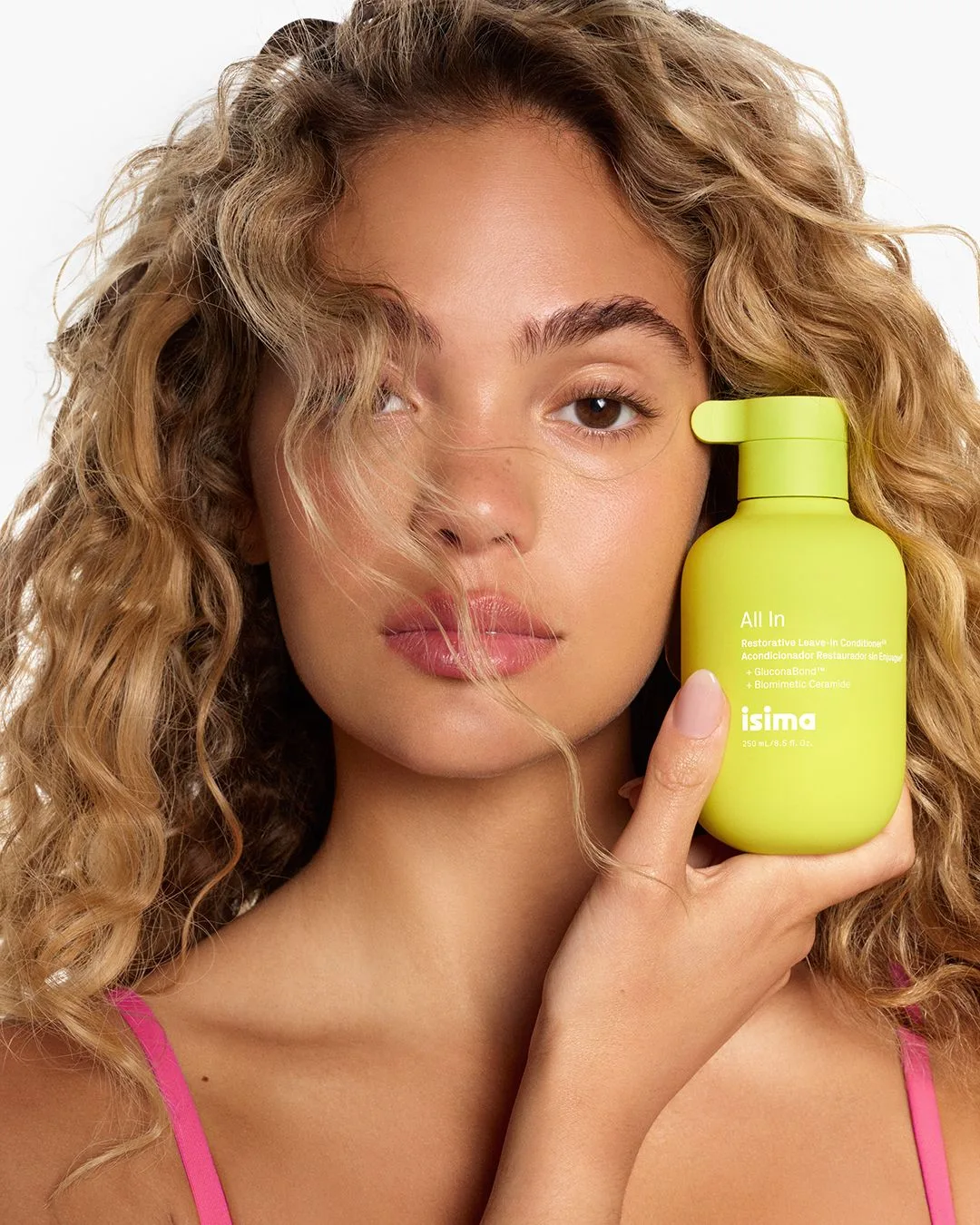 Shakira con in mano un prodotto del della sua linea haircare Isima.