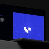 Schermata con griglia blu e logo su laptop, esempio di brand guideline digitale e costruzione del marchio.