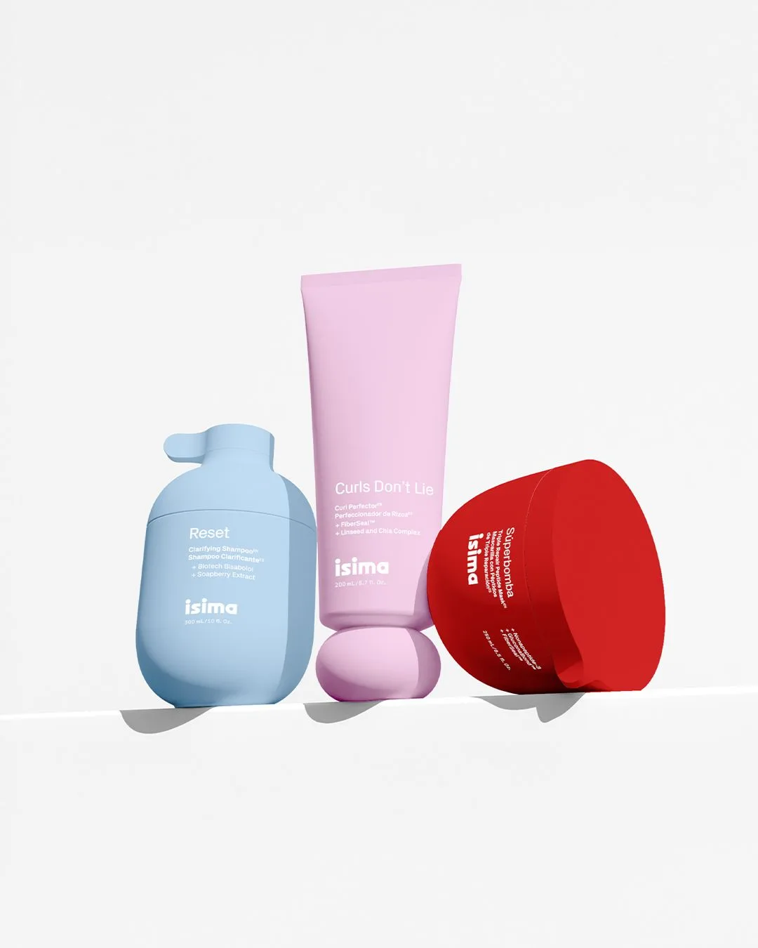 Tre prodotti del brand Isima. Packaging celeste, rosa e rosso su sfondo bianco.