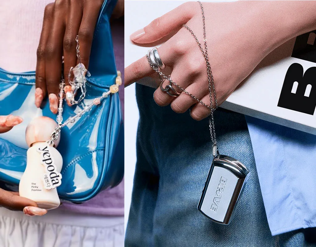 Mani con accessori cosmetici: flacone Yepoda su borsa blu e ciondolo cromato BRAVE con libro e jeans.