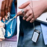 Mani con accessori cosmetici: flacone Yepoda su borsa blu e ciondolo cromato BRAVE con libro e jeans.