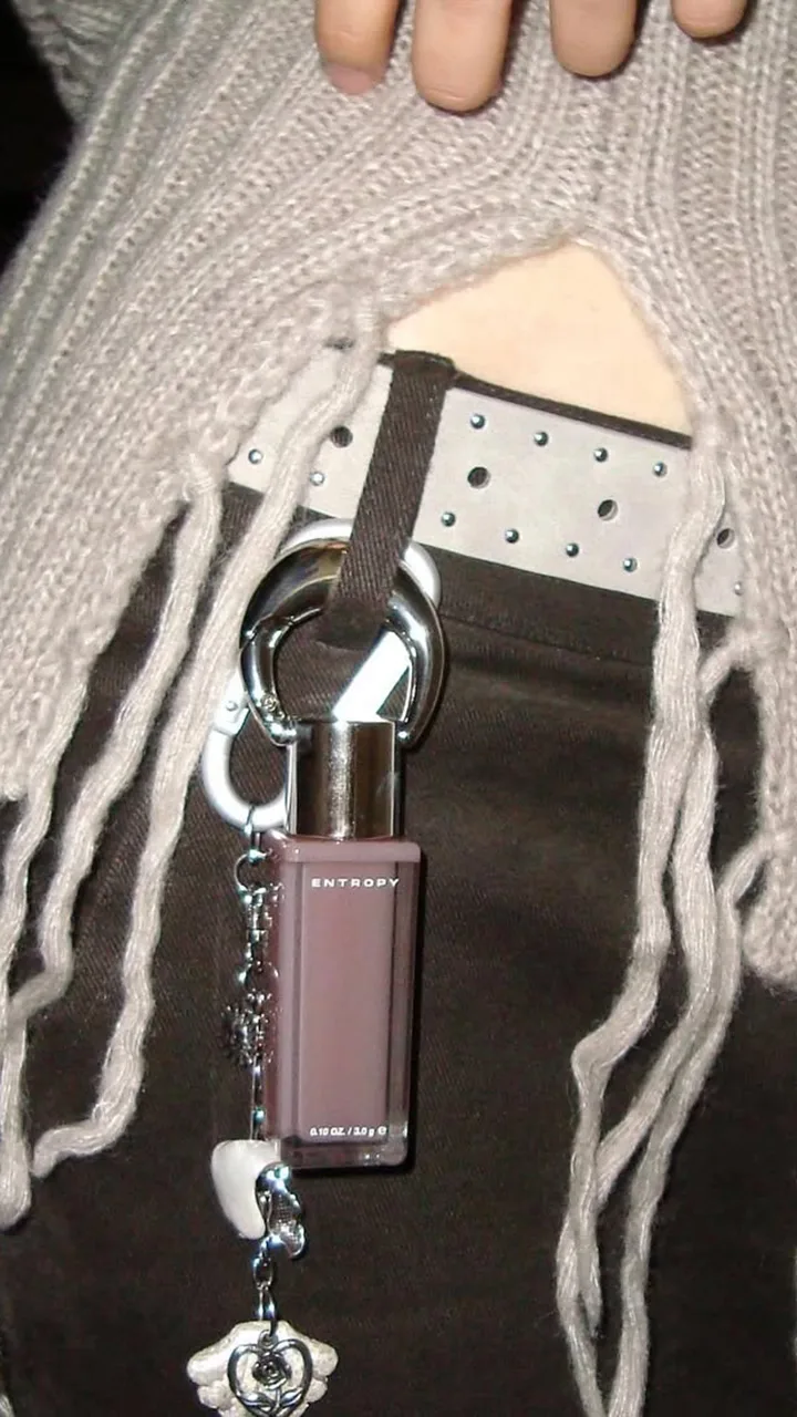 Charm Tint Glossy Gel di Entropy applicato alla cintura dei pantaloni come accessorio moda.