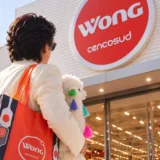 Shin Hyun-joon di spalle con borsa rossa e lama peluche davanti all'insegna Wong