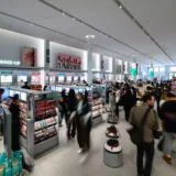 Persone tra gli scaffali di cosmesi e make-up in uno store di bellezza K-Beauty Olive Young affollato a Pasadena.