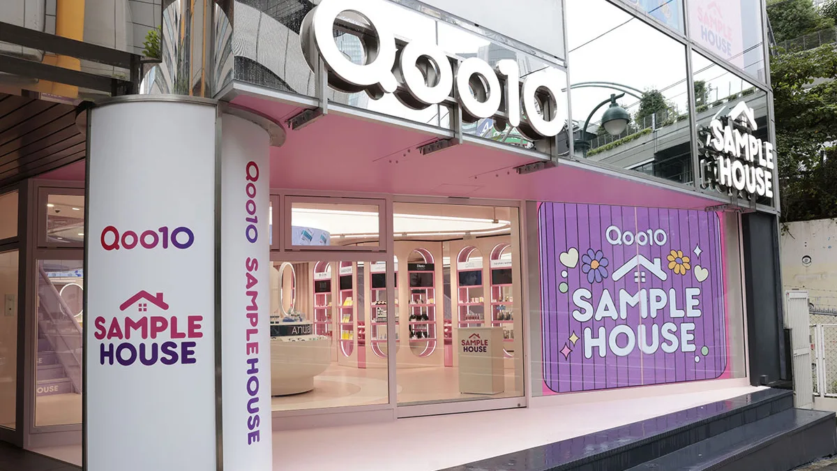 Ingresso dello showroom rosa Qoo10 Sample House a Tokyo con vetrine ed espositori di cosmetici coreani Anua